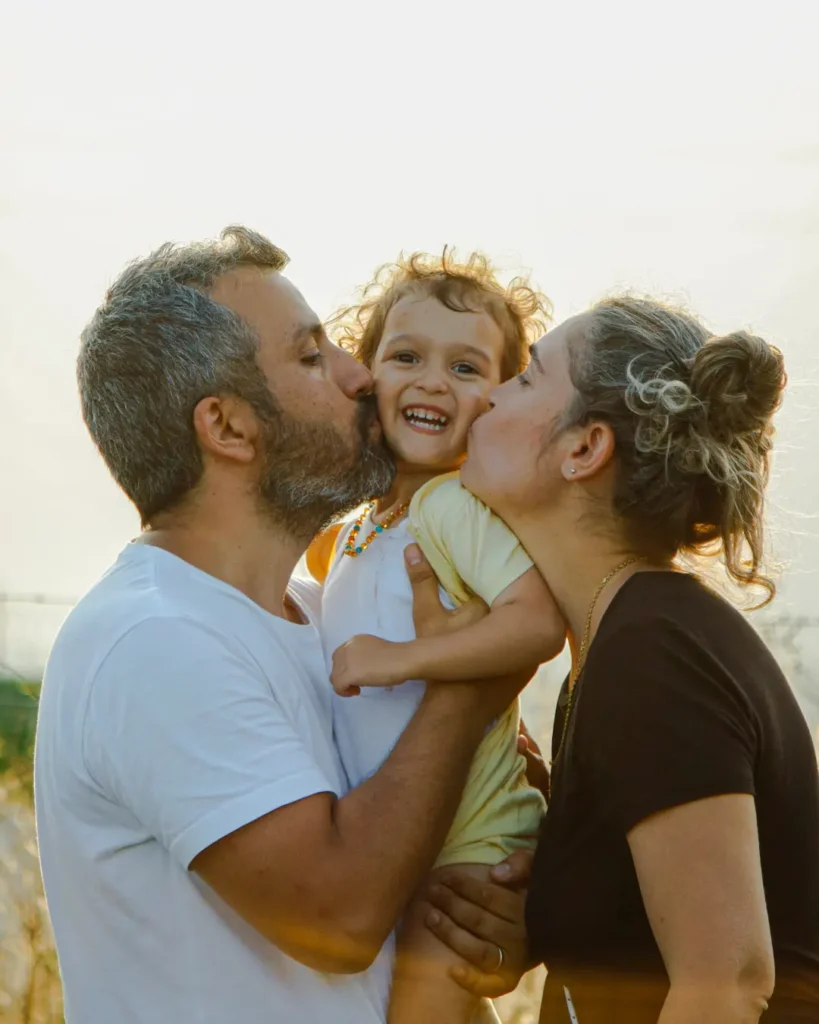 Parents Holding and Kissing Child
