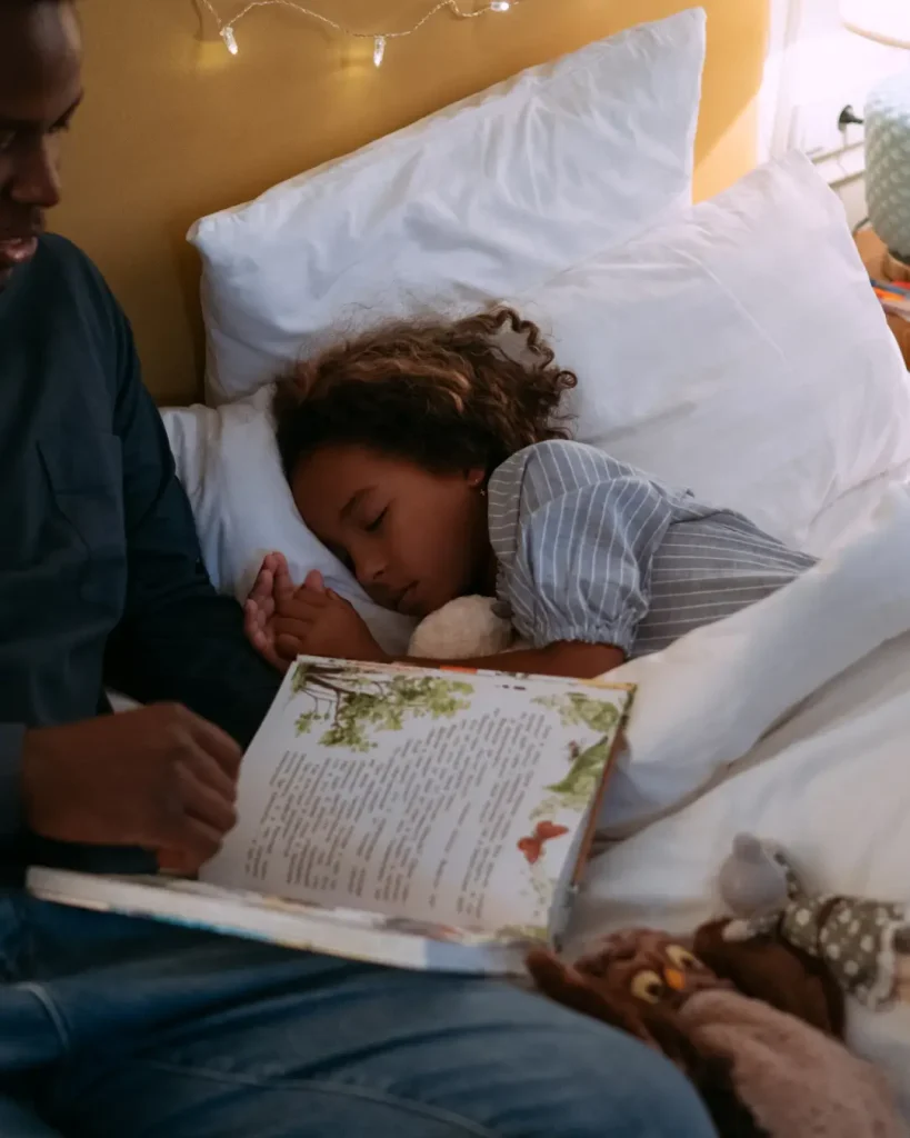 Father Reading Bedtime Story For His Daughter while Lying Down on the Bed