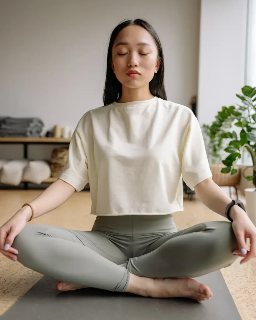 Person Sitting on Yoga Mat While Meditating
