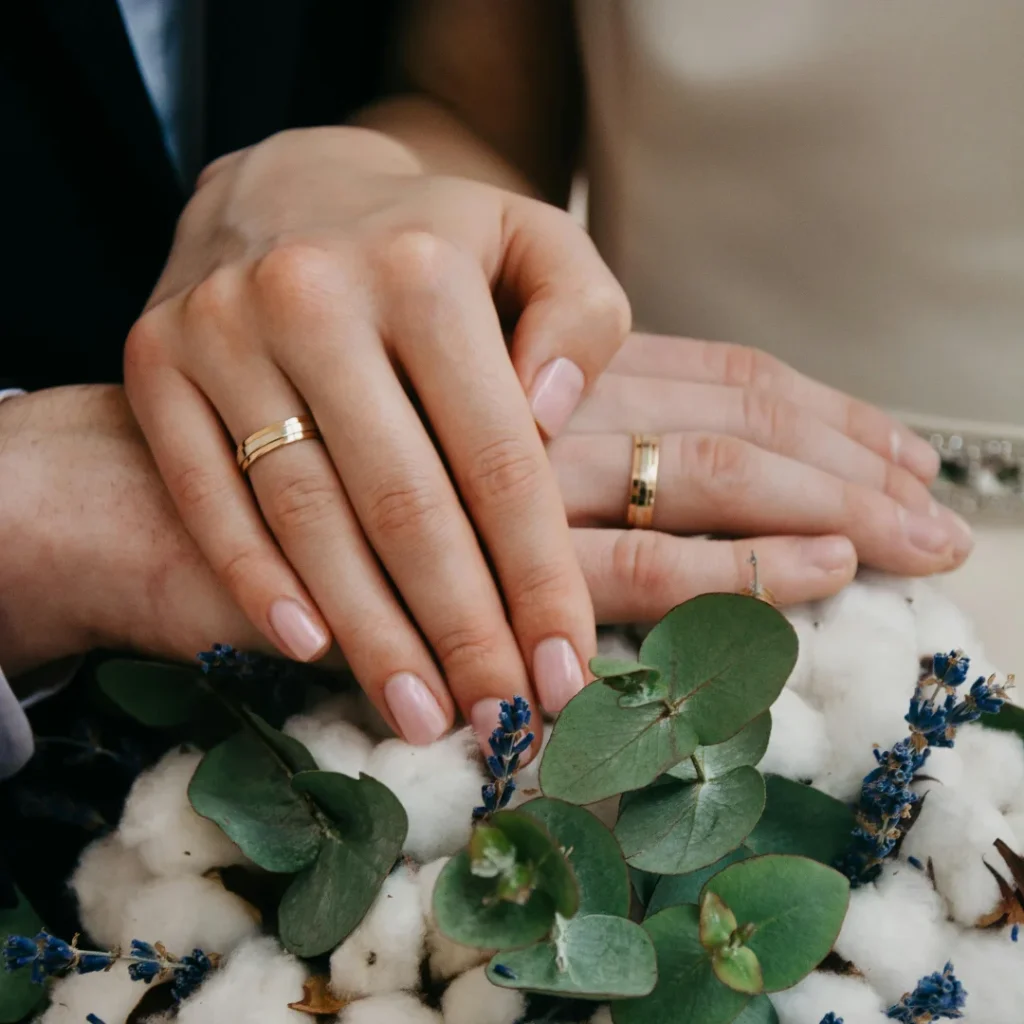 two hands touching a bouquet of flowers