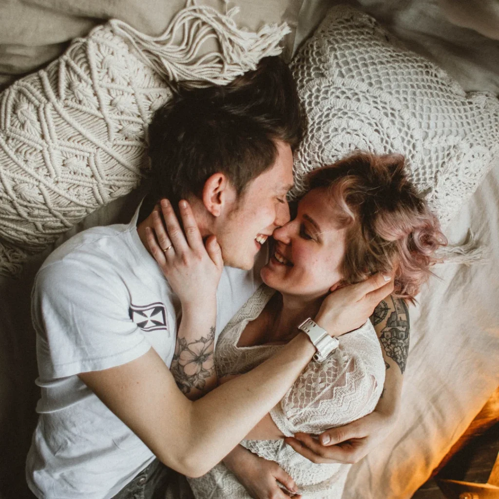 two couples hugging on a bed