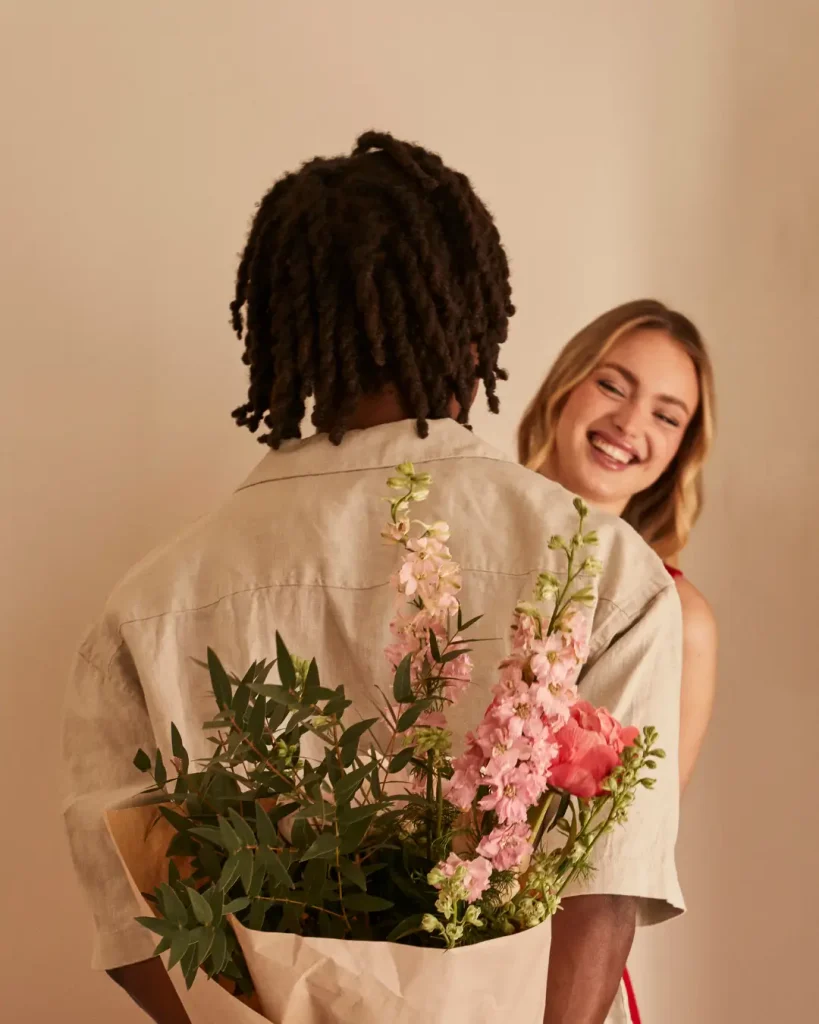 Man Surprising Woman with Bouquet of Flowers