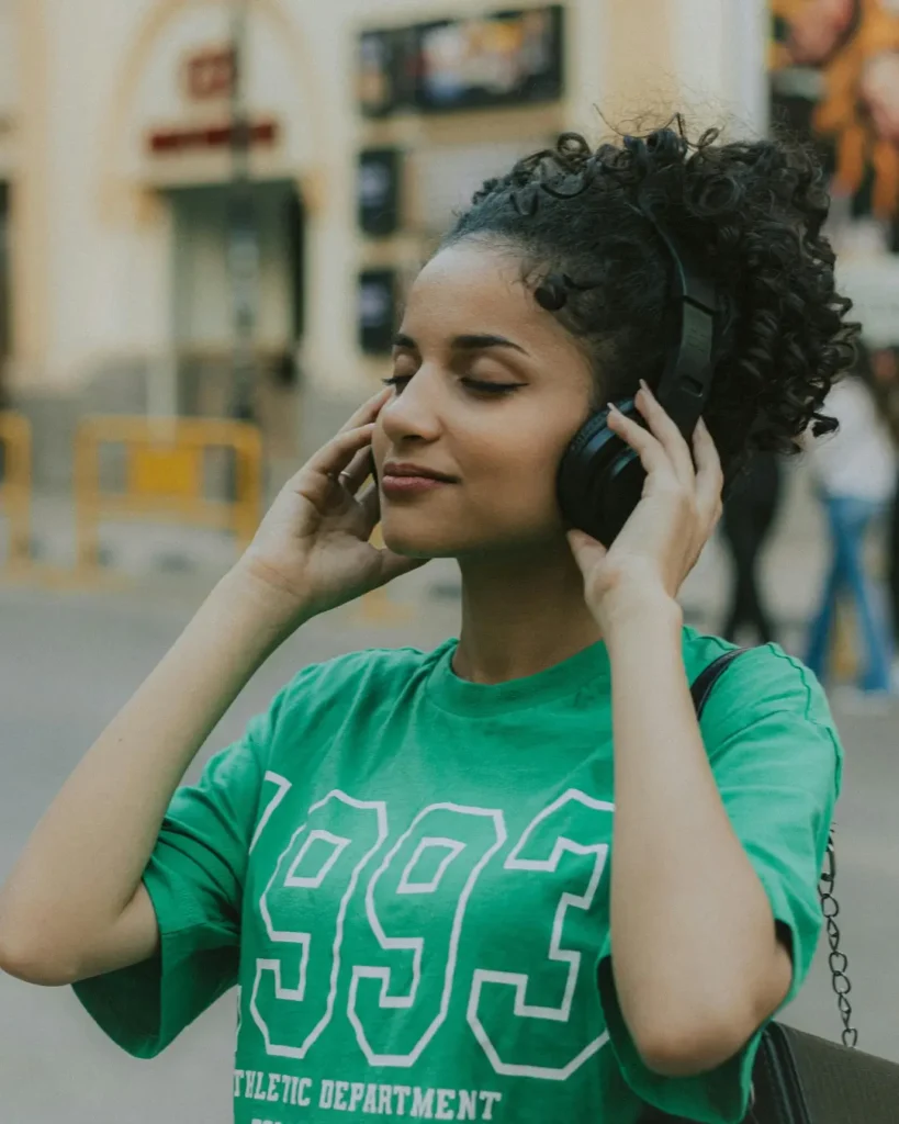Young woman enjoying music outdoors with headphones