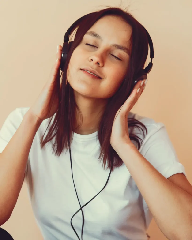 Dreamy young woman listening to music in headphones
