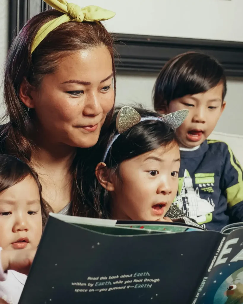 Woman Reading A Book With Her Kids