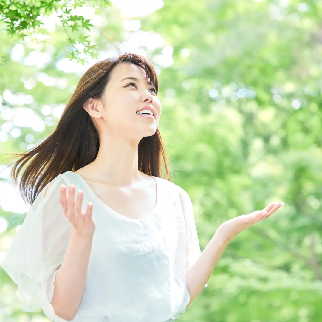 Joyful Woman with Outstretched Arms in Lush Green Park