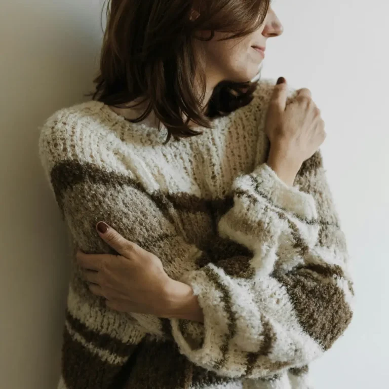 A Woman in Knit Sweater Hugging Self