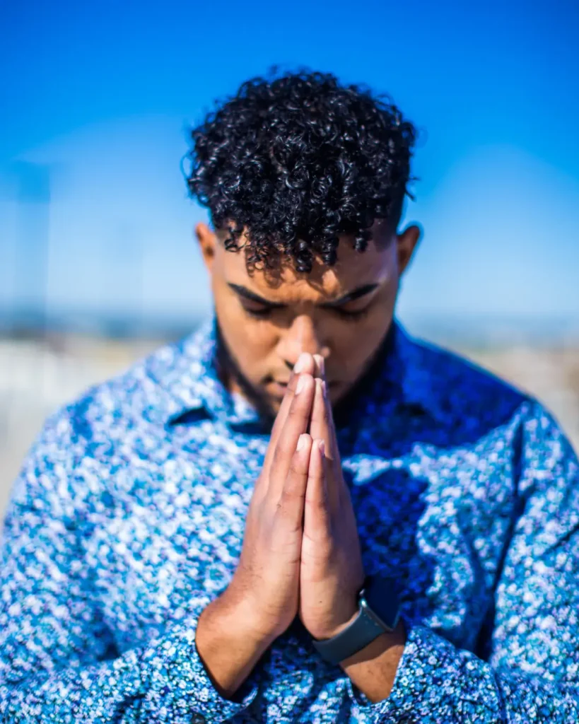 Standing Man in Blue Dress Shirt Praying