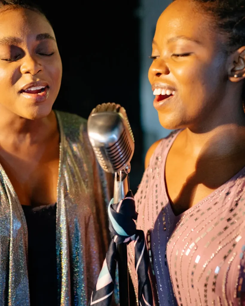 Two Women Smiling While Singing