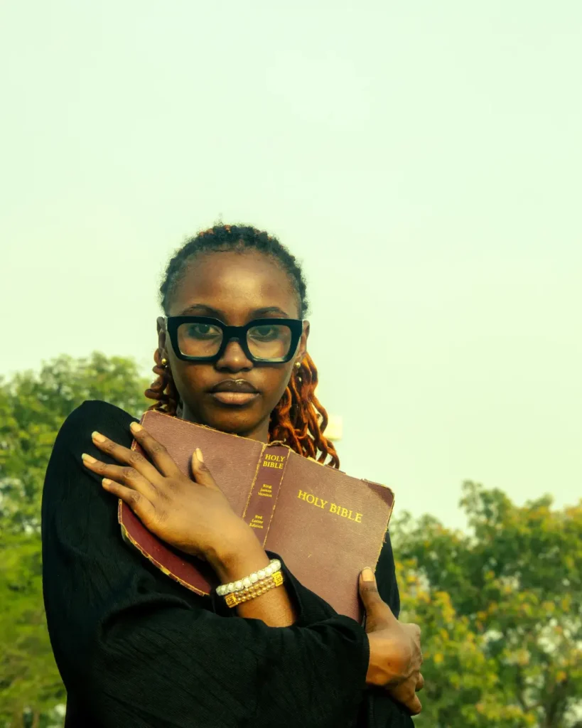 Young Woman Holding a Bible Outdoors