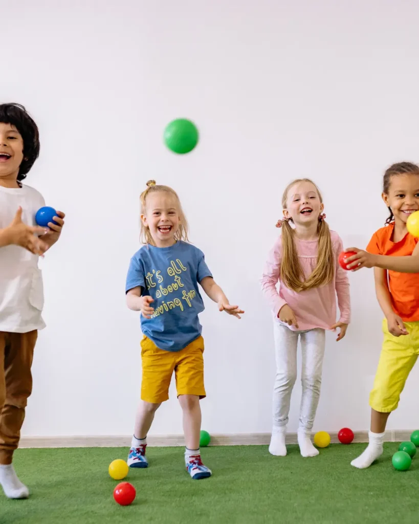 Happy Children Playing With Colorful Plastic Balls
