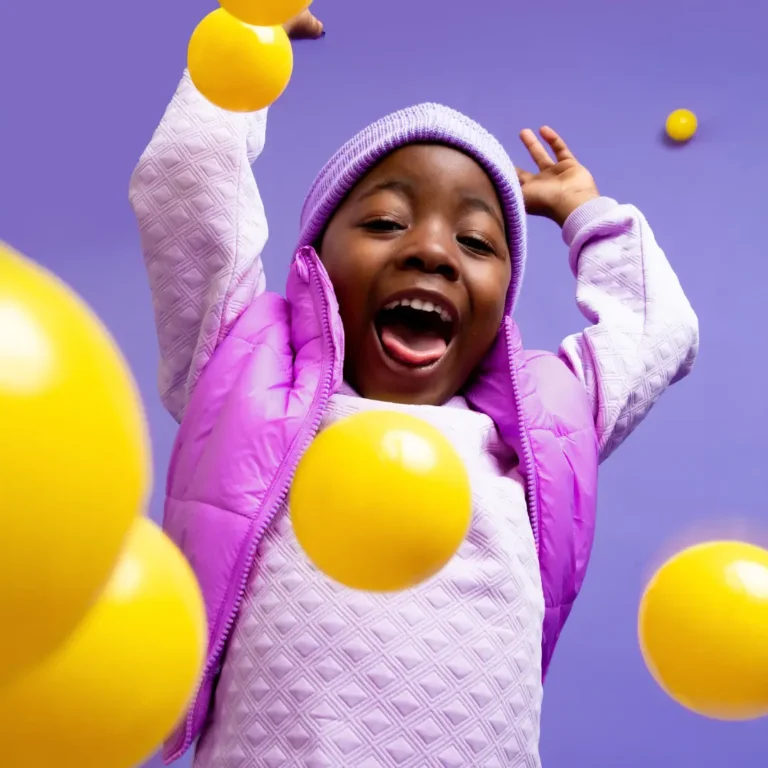 Happy Kid Playing with Yellow Balls