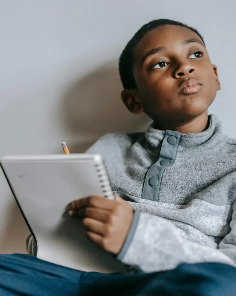 Pensive Kid with a Notepad