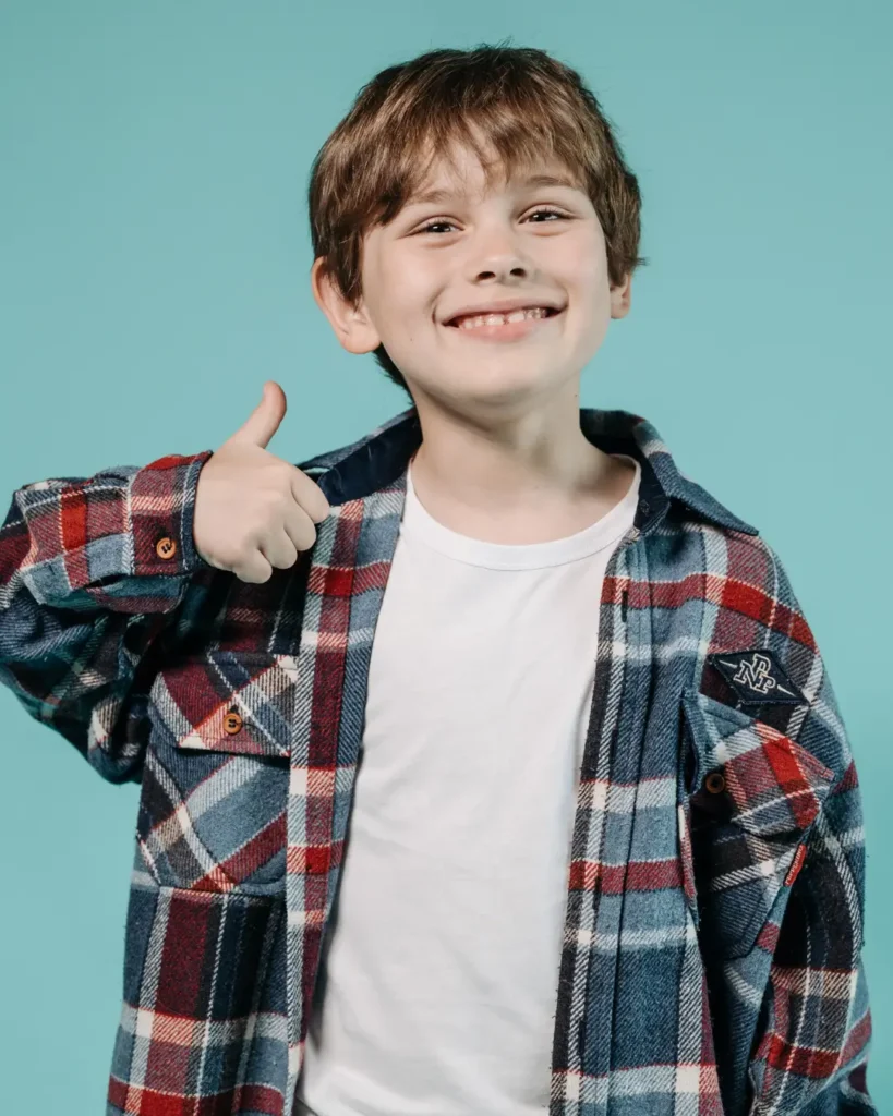 Boy in Red and Black Plaid Long Sleeve Shirt Doing a Thumbs Up