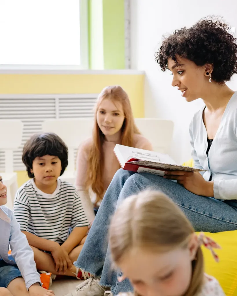 Woman Reading A Book To The Children