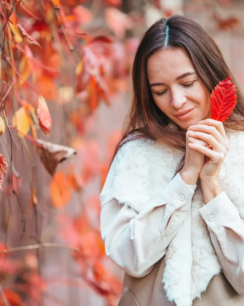 Fall Concept - Beautiful Woman in Autumn Park under Fall Foliage