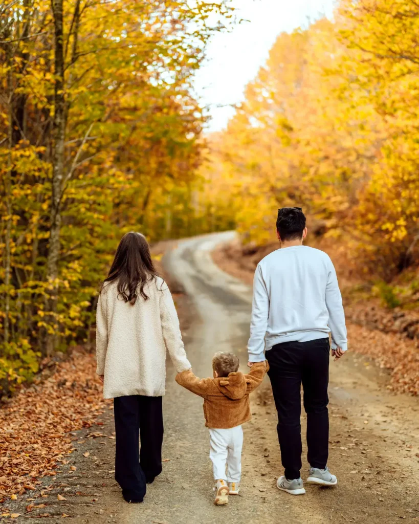 Family walking on autumn forest path