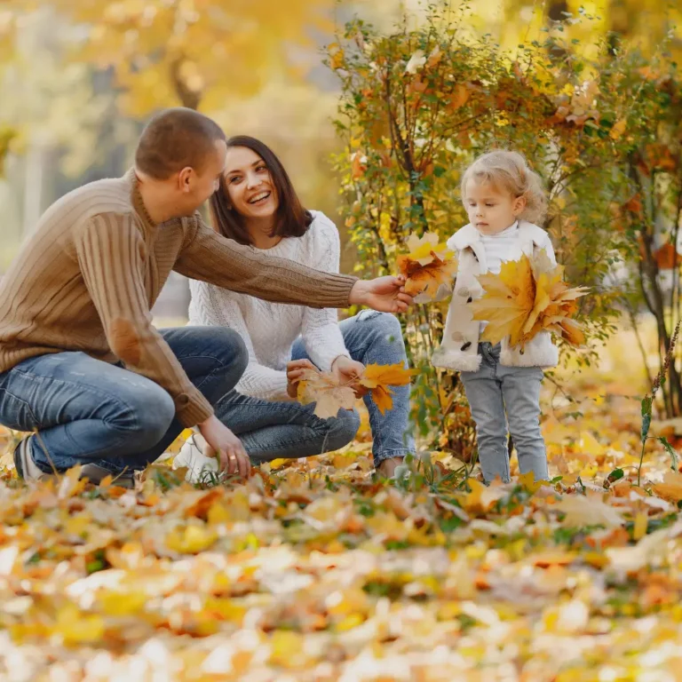Happy family with little daughter in autumn park