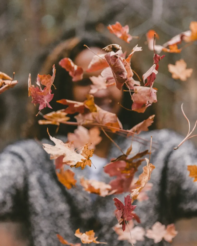 Woman Playing with Autumn Leaves